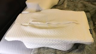 A Zamat Butterfly Shaped Cervical Memory Foam Pillow turned upside-down and unzipped