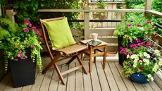 A small decked backyard with wooden furniture