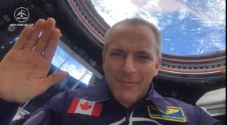 Canadian Space Agency David Saint-Jacques waves a "Happy New Year" message to Earth fro 2019 from the Cupola of the International Space Station on Jan. 1, 2019.