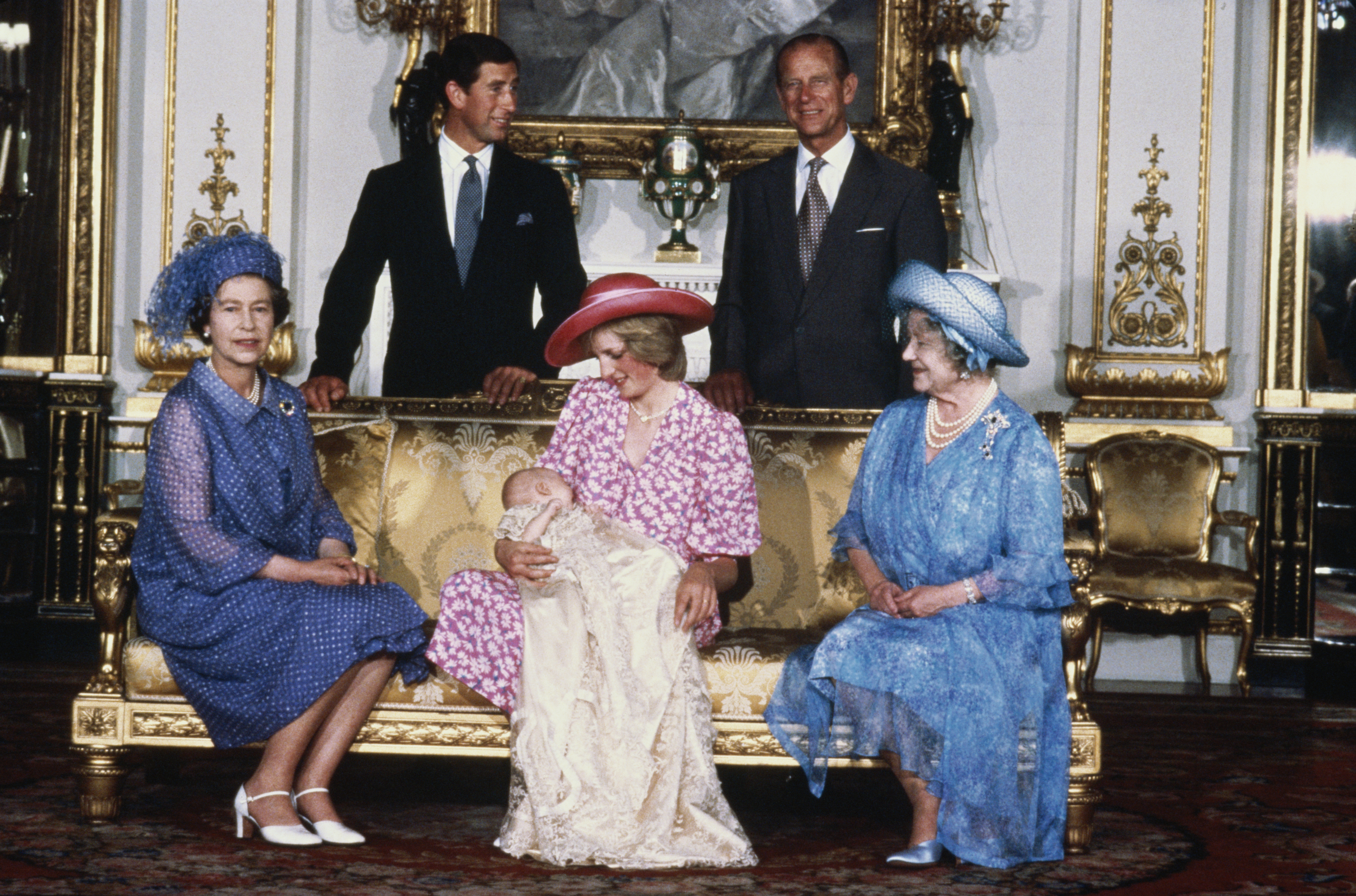 Princess Diana wears a pink floral dress and pink hat to hold Prince William on August 4, 1982 at his royal christening