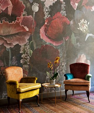 colorful study with oversized floral wallpaper, colorful velvet armchairs and patterned rug
