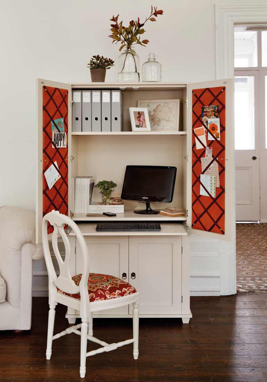 a white and red armoire with shelves and a desk housing folders and a computer, with doors to close, and a white and red chair