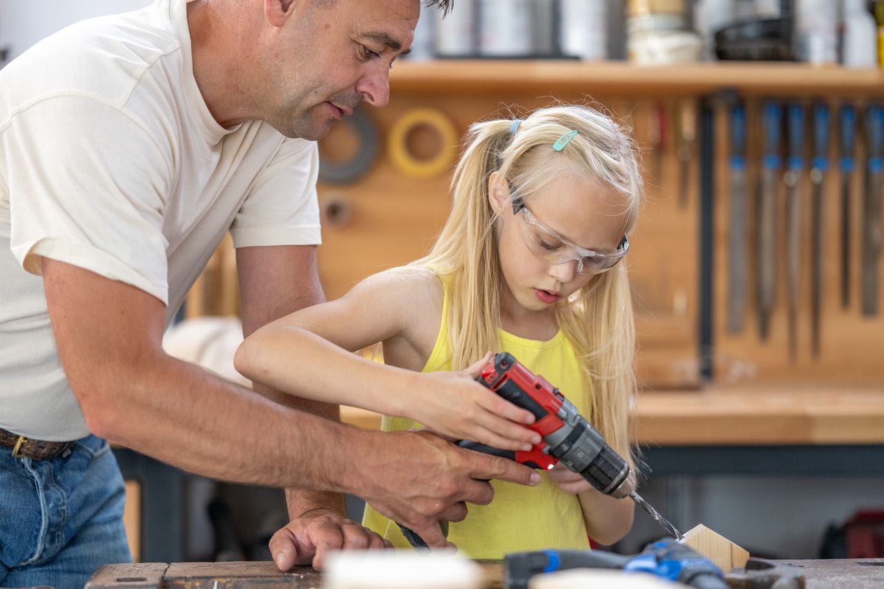 Girl making handmade house, screwing with electrical equipmen