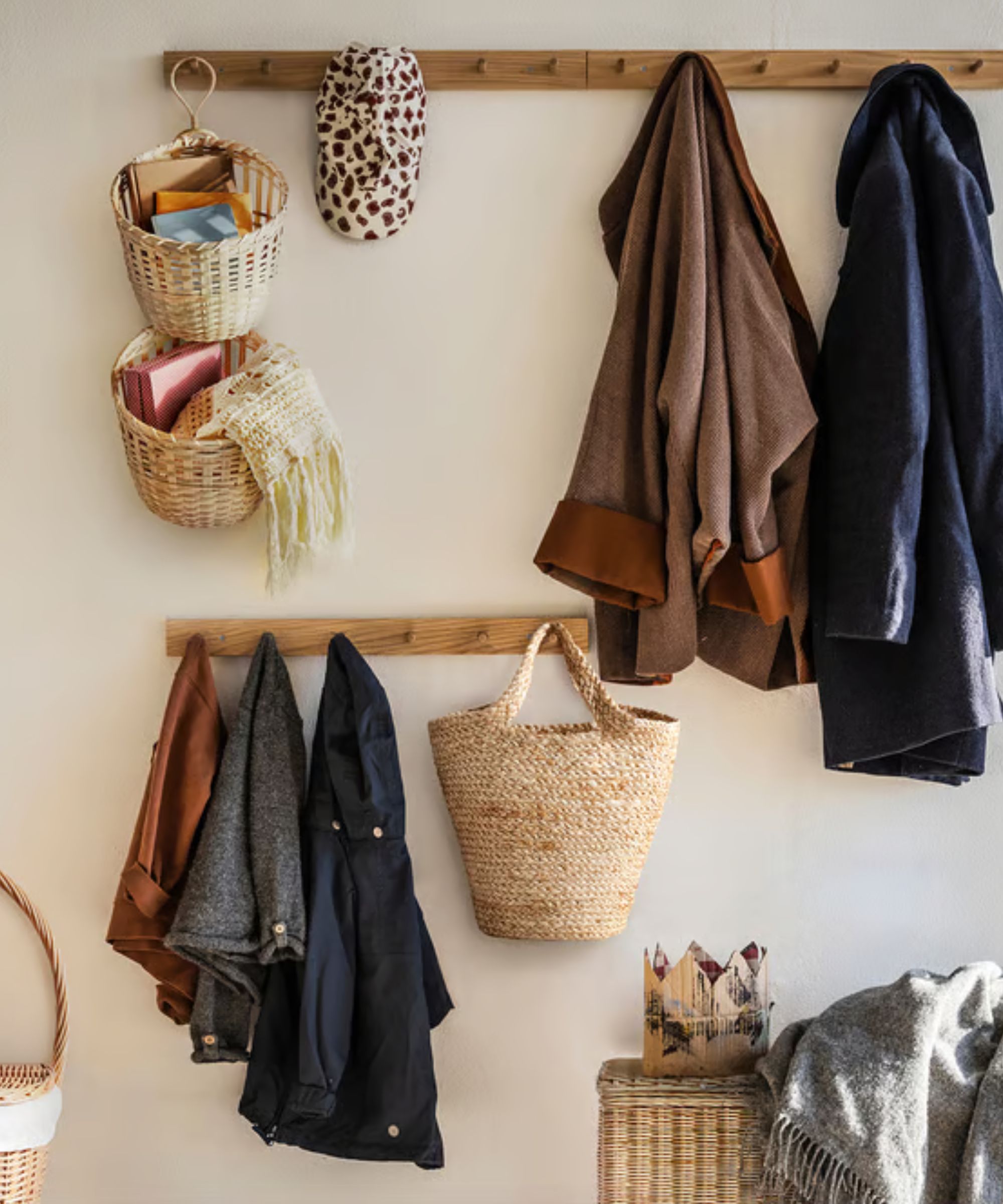 Entryway with coats and bags hanging on hooks and wicker baskets