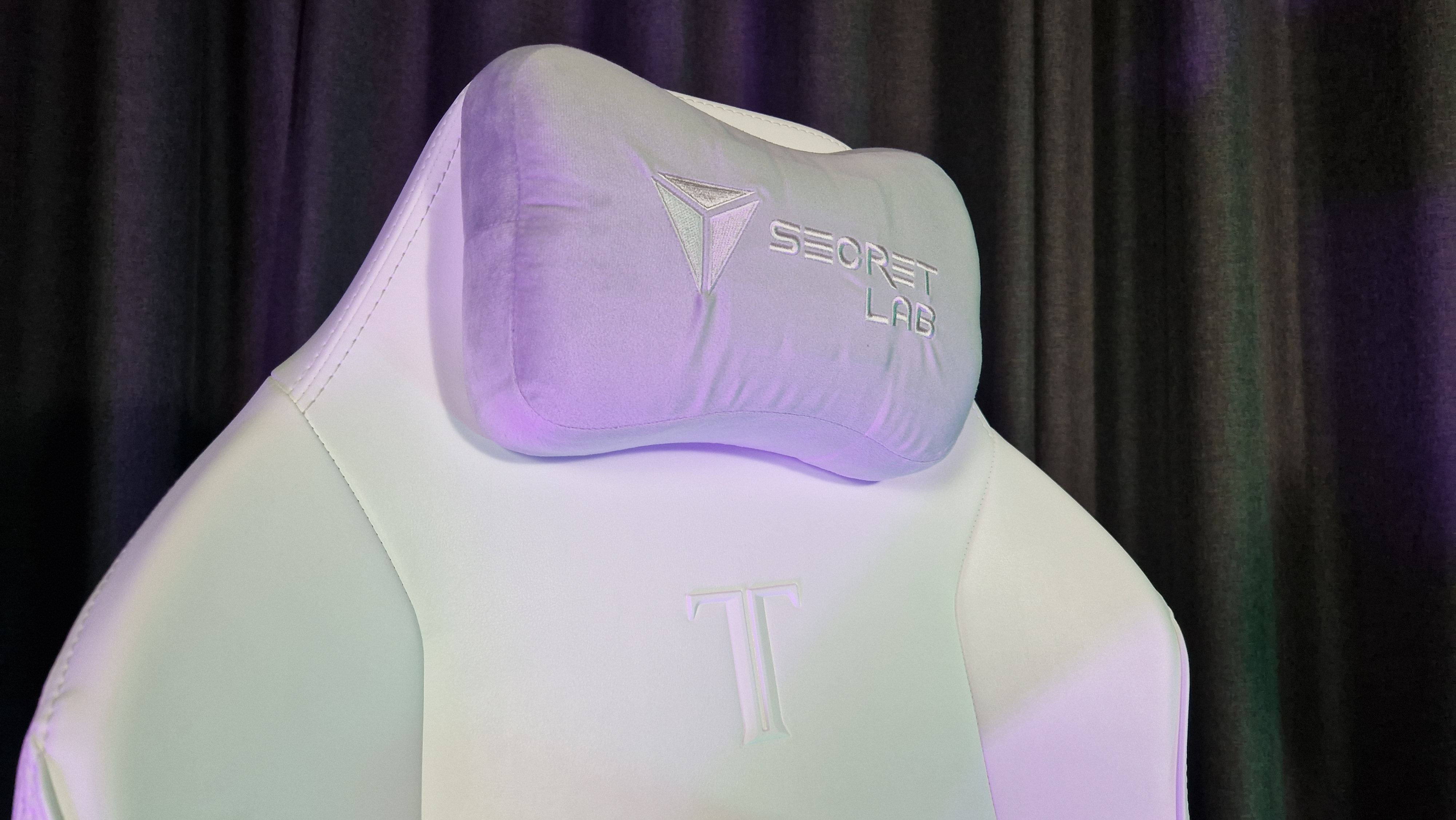 The Secretlab Titan Evo NanoGen Edition chair on a grey floor with grey curtains behind it