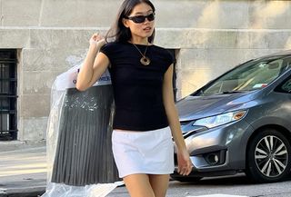 Woman in white miniskirt and black top.