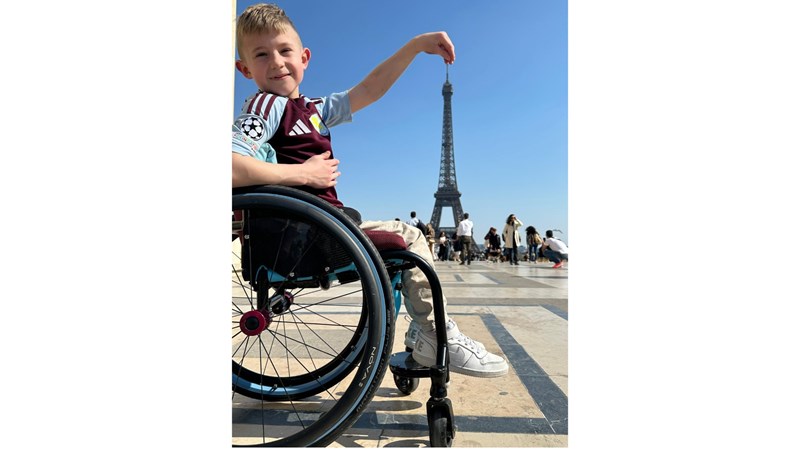 Ted Haslem in a wheelchair in front of the Eiffel Tower