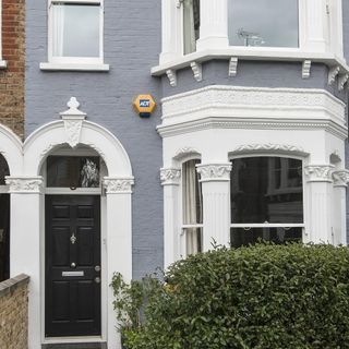 house exterior with grey wall and black door and white window