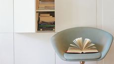 blue chair with white cupboard and book