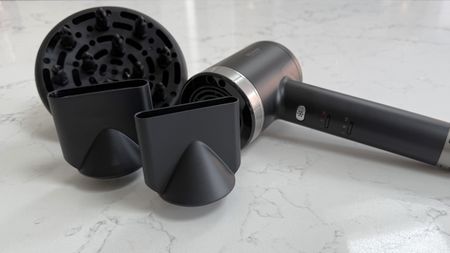 Revamp Tri-Care hair dryer placed alongside its diffuser and concentrator nozzles