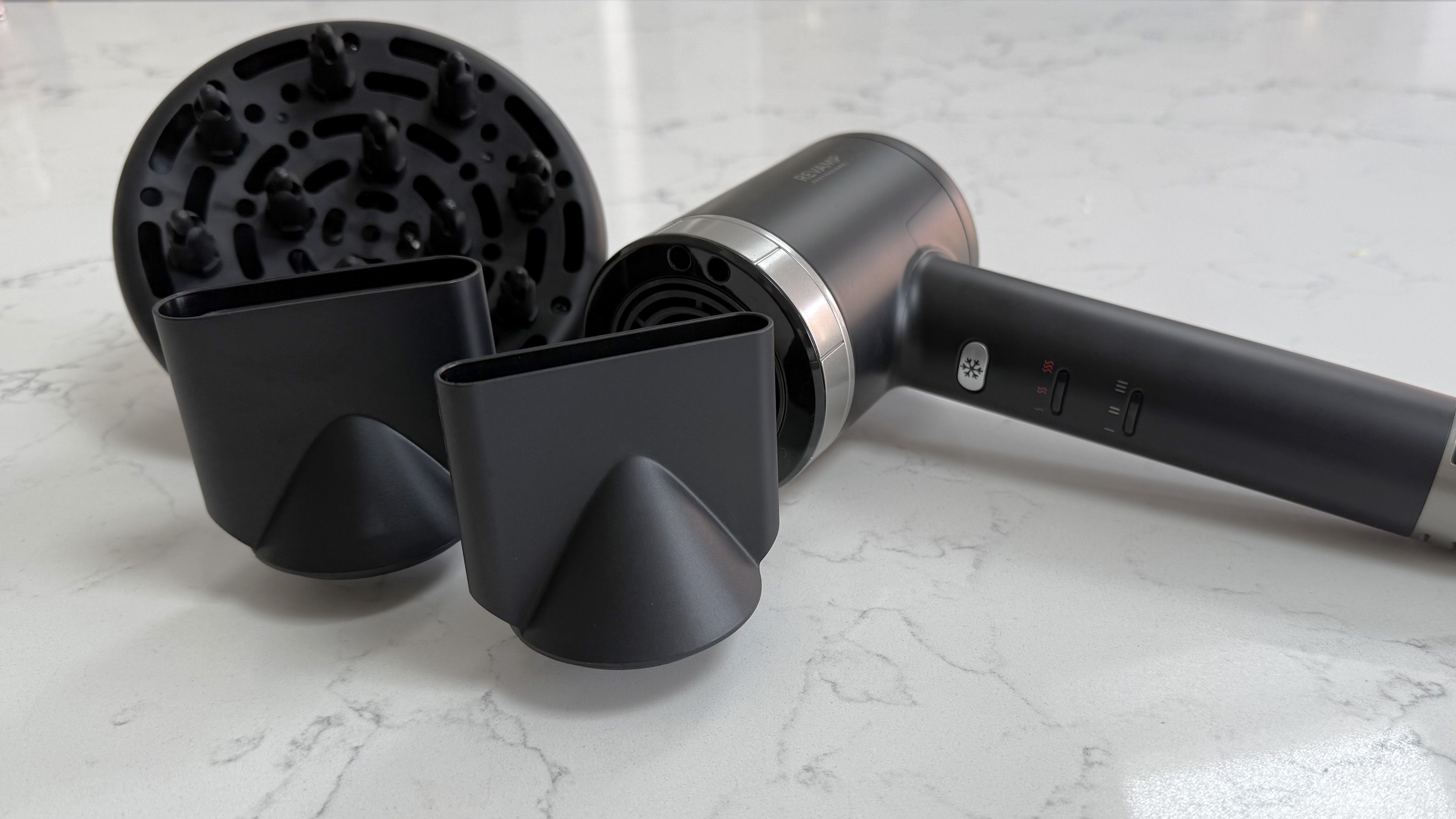 Revamp Tri-Care hair dryer placed alongside its diffuser and concentrator nozzles