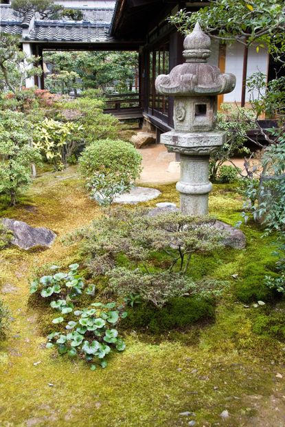 Japanese Zen Style Garden With Shrubs And A Statue