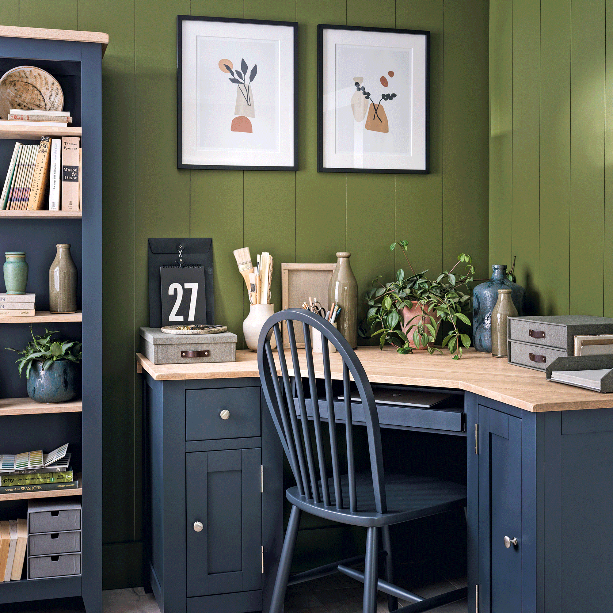 Blue desk with wooden top and green walls