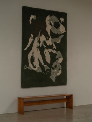 Green hand tufted rug with a motif inspired by the movement of water
