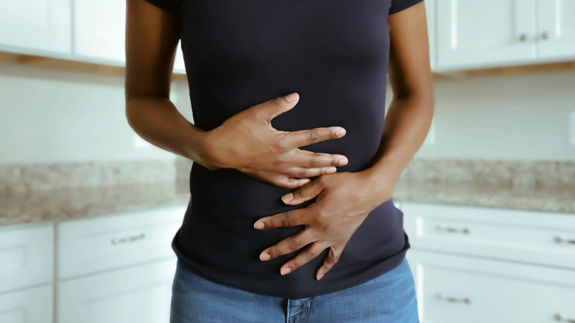 woman holding her stomach in pain