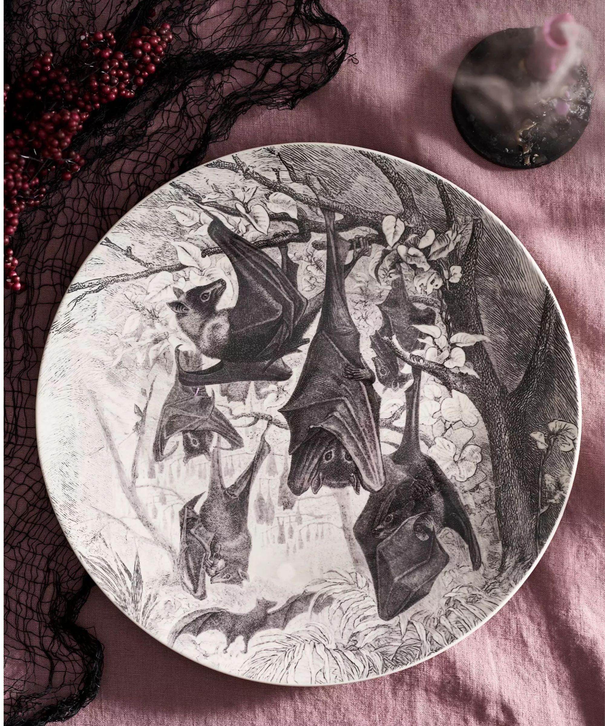 Mauve tablecloth with a black and white Halloween serving plate depicting sleeping bats