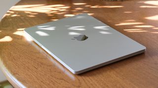 Apple MacBook Air with the lid closed sitting on a wooden table