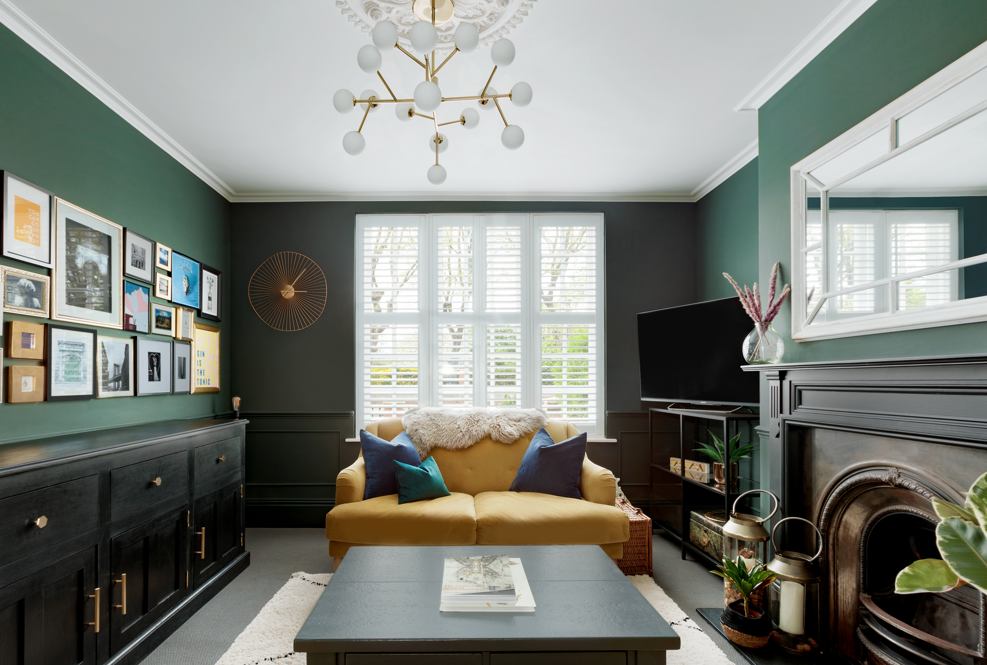 A living room with green walls, a yellow sofa, and a TV in the corner