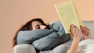 Woman with the infinity pillow wrapped around their neck