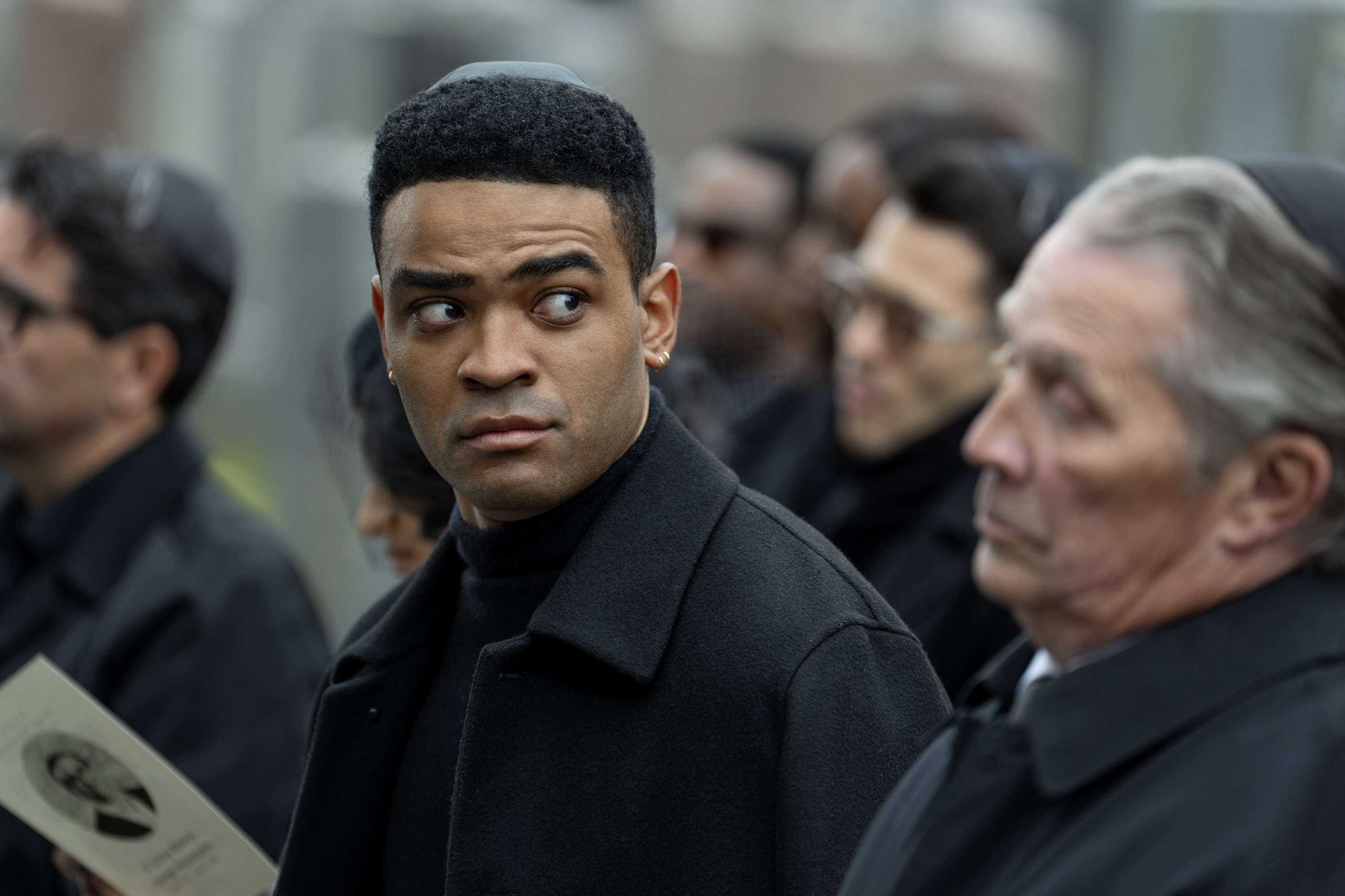 Owen Thiele as Anton, looking at a older man while seated at a funeral, in 'Adults.'