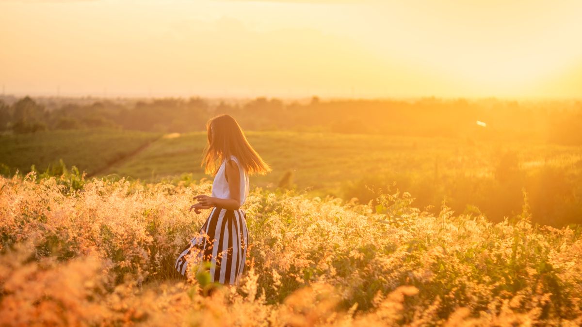 woman walking through sunny field