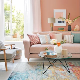 best colour combinations, Peach wall with cushion and sofa, artwork, coffee table, cushions