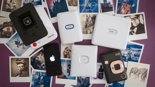 A selection of the best iPhone printers from Instax and Polaroid, on a purple table surrounded by printed photographs
