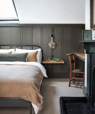 bedroom with Velux window, gray panelling, glass pendant light and black iron bed