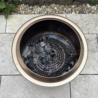 steel fire pit inside with ash in the bottom