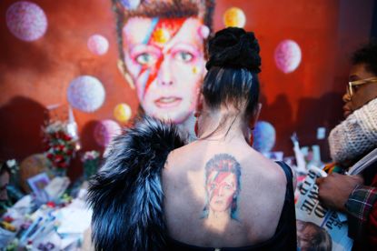 Mourners gather at a makeshift David Bowie memorial.