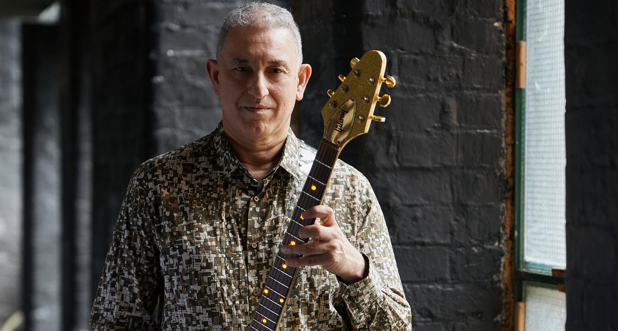 Aziz Ibrahim is photographed at home with some of his favourite guitars
