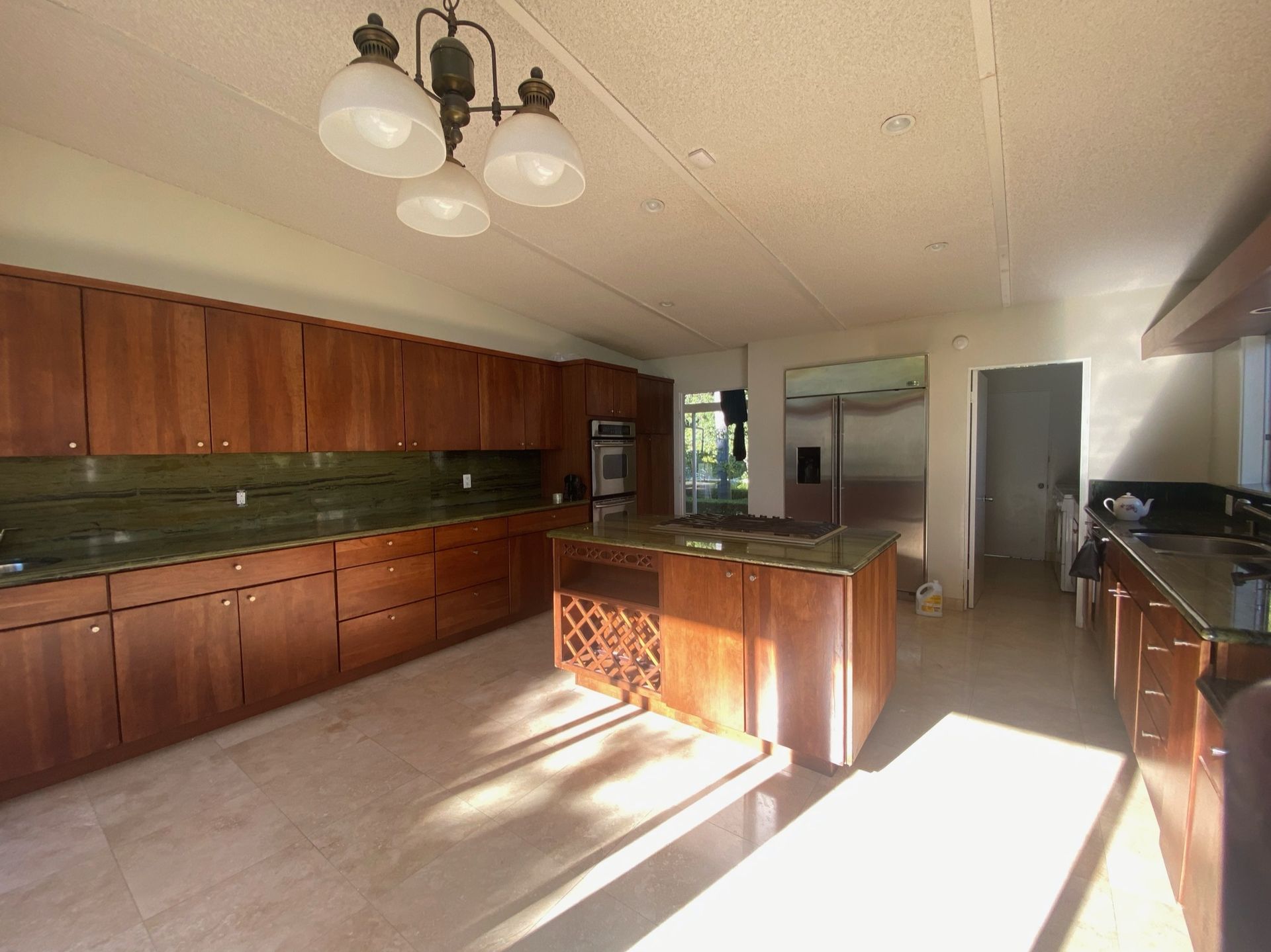 A dated kitchen with tiled flooring and dark wooden cabinetry