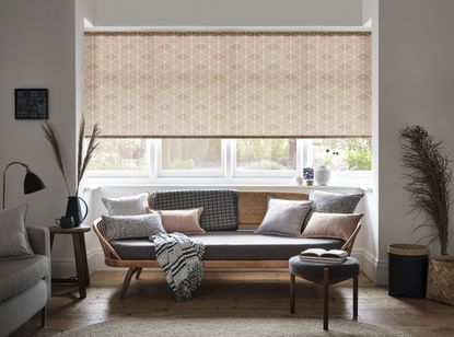 A reverse rolled pink geometric patterned roller blind