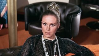 Joanna Lumley sits stunned in the lounge in On Her Majesty's Secret Service.