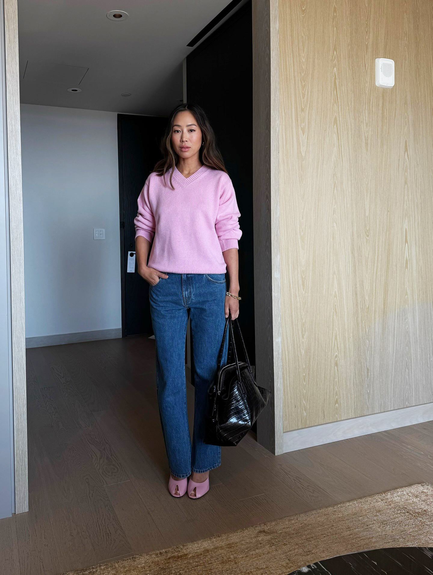 Aimee Song wearing a pink V-neck sweater