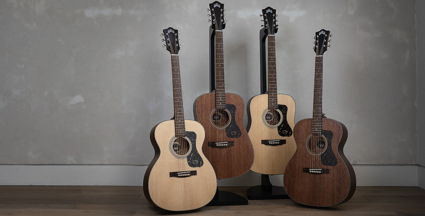 Four Guild guitars against a gray background