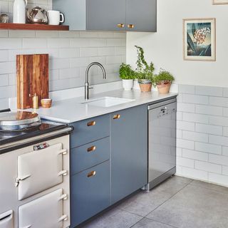 blue kitchen cabinets white tiled splashback and small upstand
