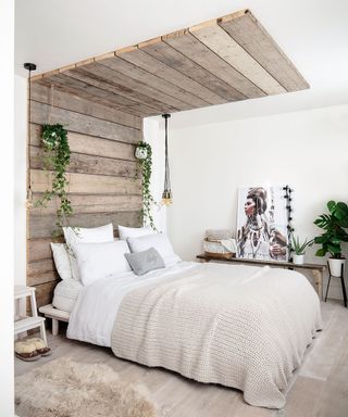 Bedroom with wood panels stacked on wall that flow to the ceiling