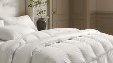 A bed with a duvet insert and pillows on