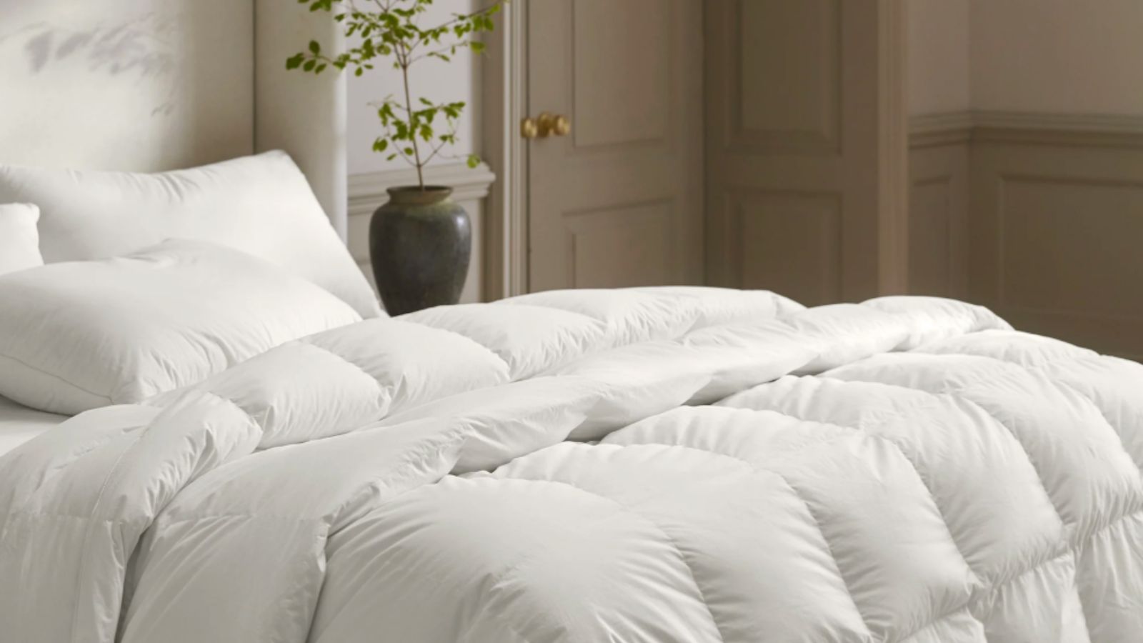 A bed with a duvet insert and pillows on