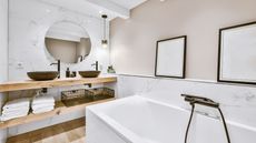 White and cream bathroom with wooden shelves and black features