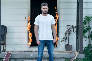 Firestarter star Zac Efron outside a burning building