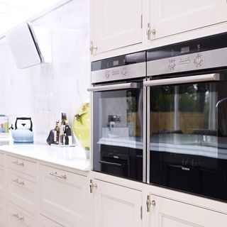 Built-in double mirror front Siemens ovens in white and beige kitchen