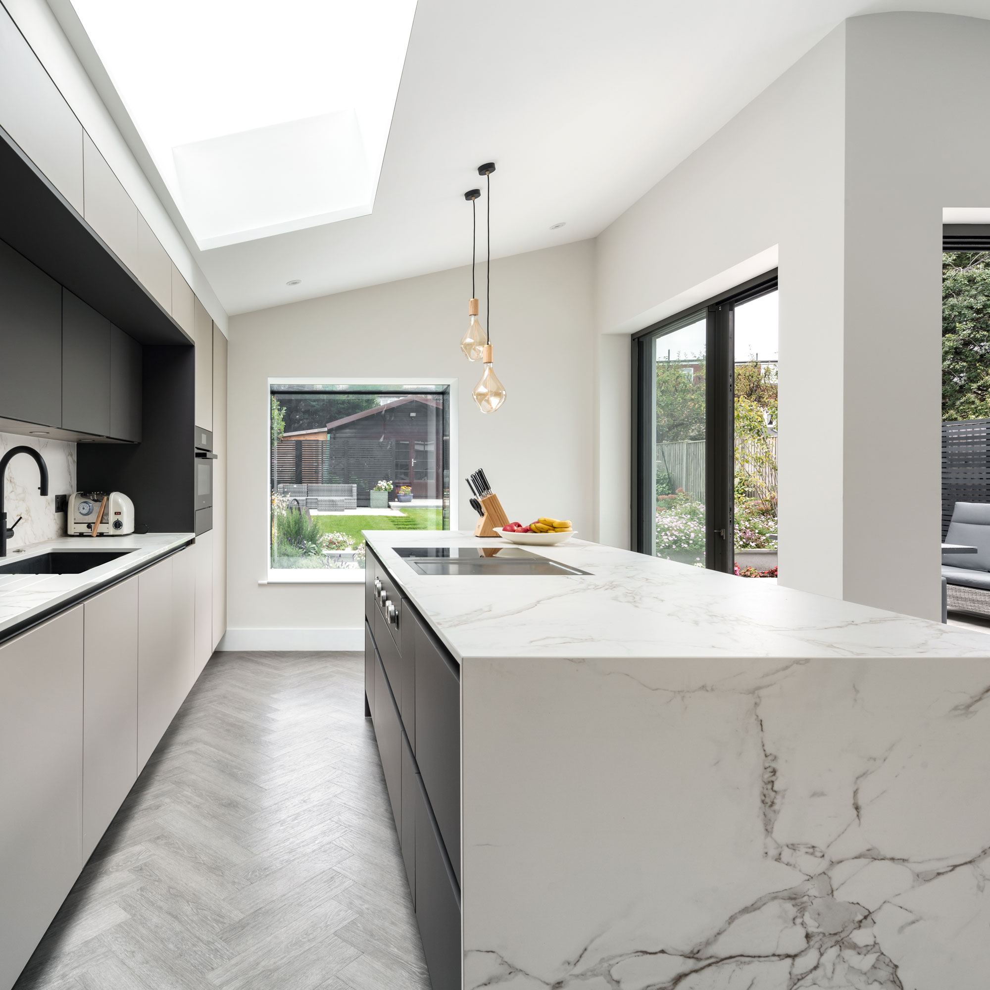 L-shaped modern kitchen extension with marble waterfall worktops