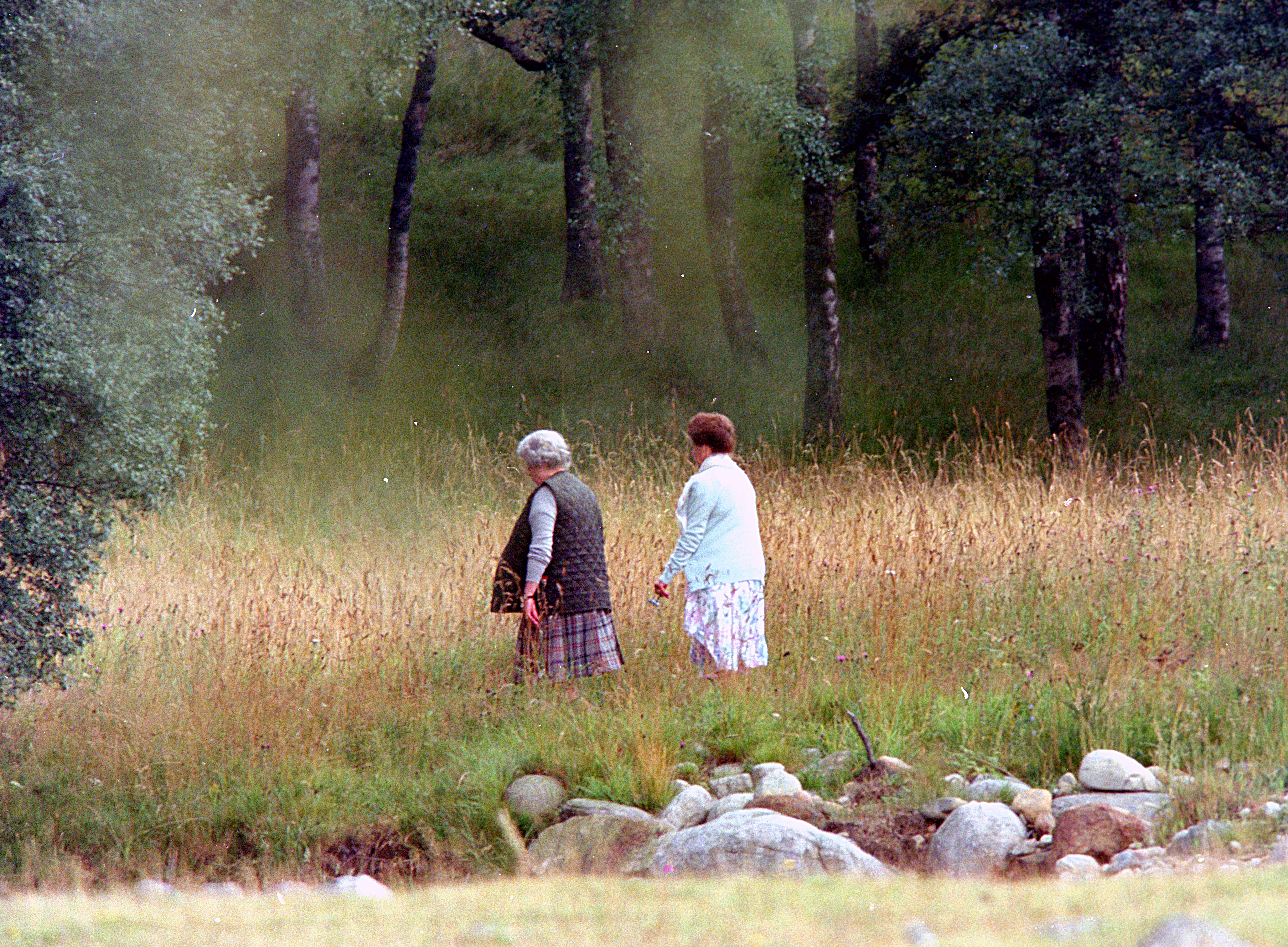Queen Elizabeth and Princess Margaret walking in the woods at Balmoral