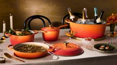 A table of champagne and celebration dishes served in Le Creuset's 100th anniversary Flamme Doree collection