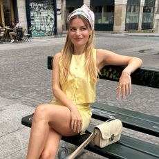 Influencer @sabinasocol wears a yellow two piece with a silk headscarf and pointed toe mules.