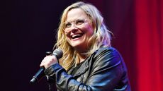 Amy Poehler holds a microphone