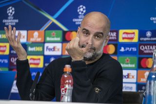 Manchester City boss Pep Guardiola shrugs expressively at a press conference