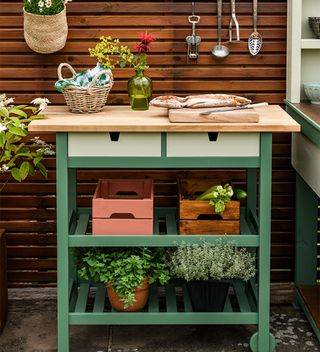 green potting bench as a food prep area with herbs